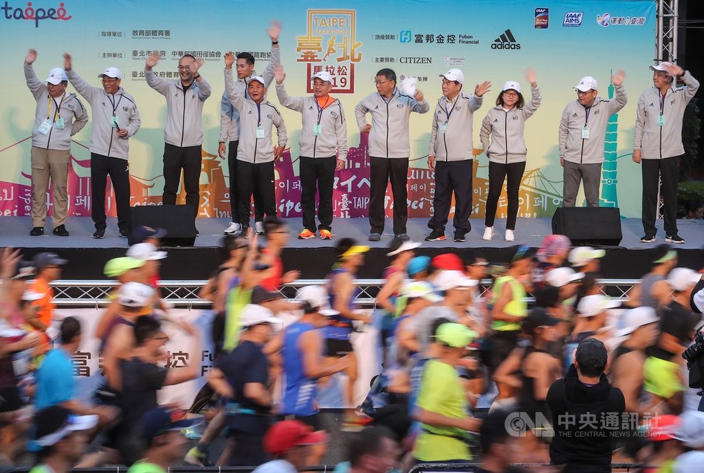 2019台北馬拉松15日在台北市政府前廣場開跑,台北市長柯文哲(右5)出席與會,揮手為跑者加油打氣。中央社記者裴禛攝 108年12月15日