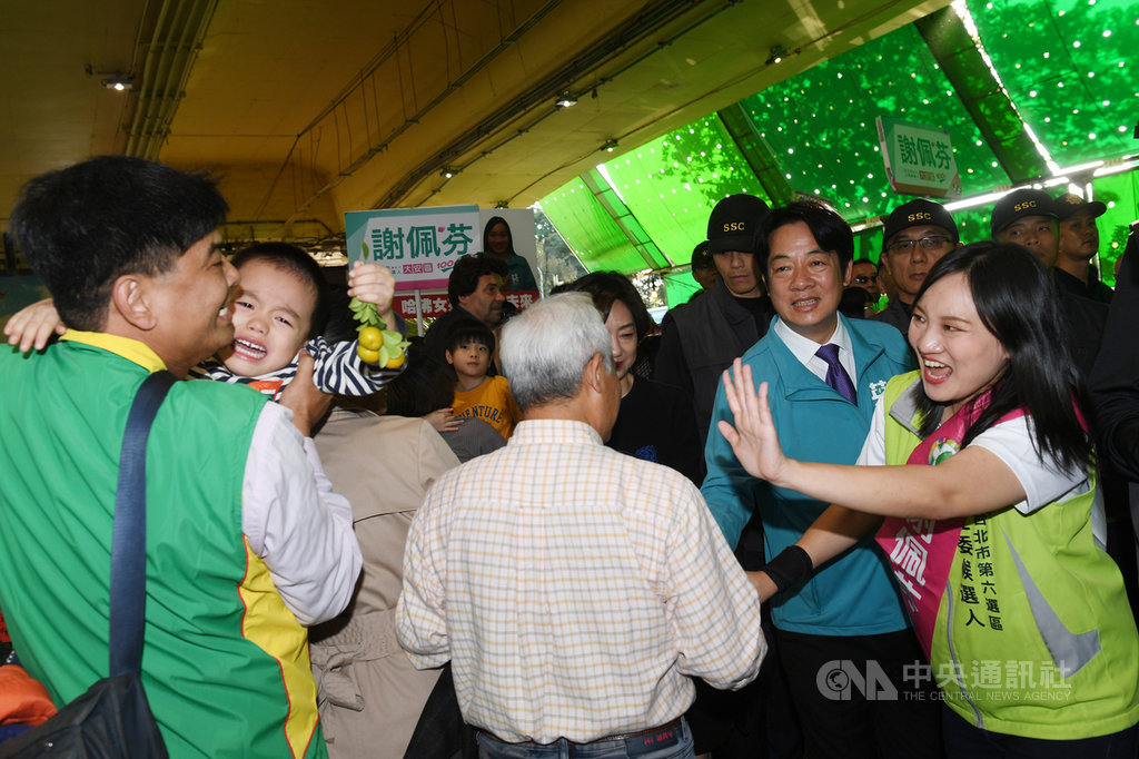 民進黨副總統候選人賴清德(前右2)15日陪同同黨立委參選人謝佩芬(前右)到建國花市拜票,一名父親熱心伸手握手,懷中兒子卻被擁擠人潮嚇到哭了起來。中央社記者施宗暉攝 108年12月15日