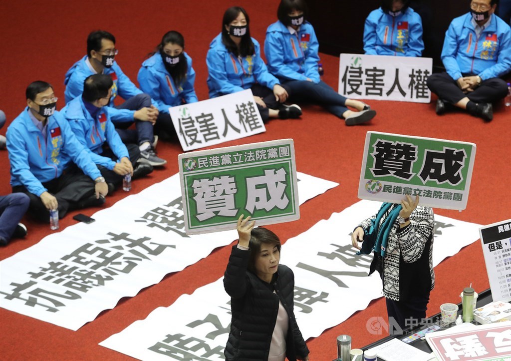 立法院會31日開始處理反滲透法草案,將逐條發言、表決,力拚在本屆會期最後一天完成三讀,但朝野無共識,國民黨立委坐在議場中,表達反對立場,民進黨團則舉牌表示贊成。中央社記者張皓安攝 108年12月31日