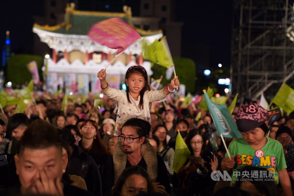 2020大選11日即將投票,民進黨10日選前之夜在台北凱達格蘭大道辦造勢催票,不少大小朋友一起到場參與,有孩子坐在大人肩頭,開心揮舞手中旗幟。中央社記者徐肇昌攝 109年1月10日