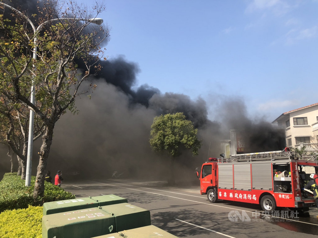 苗栗市國華路一家汽車鈑金廠14日發生火警,火舌在鐵皮廠房內悶燒,不時傳出爆炸聲響,還冒出陣陣黑煙。中央社記者管瑞平攝 109年1月14日