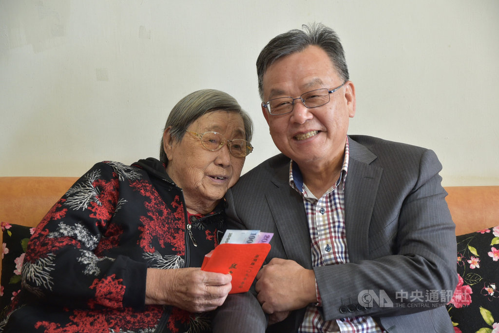 農曆春節將屆,澎湖縣長賴峰偉(右)14日前往86歲長者曾陳寶雙(左)家中致贈敬老禮金,讓長輩相當歡喜。中央社 109年1月14日