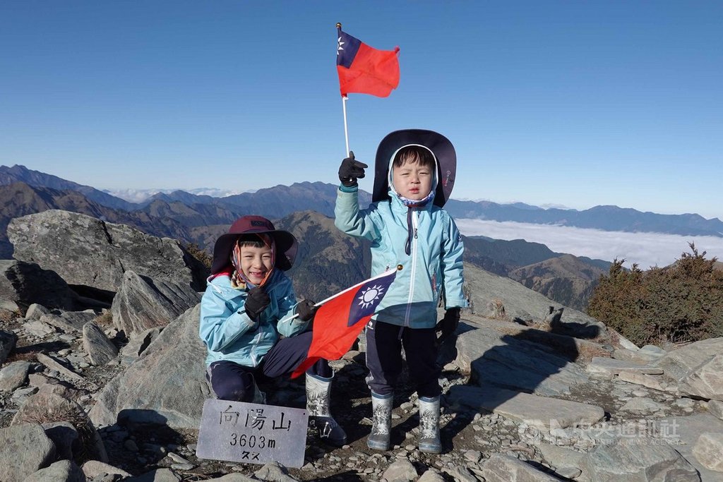 住在新北市的7歲阿興、5歲阿賢兄弟,今年1月初與父母一起攀登百岳排名16、海拔3603公尺的向陽山,登頂時兩人揮舞國旗,模樣萌翻天。(邱德鑫提供)中央社記者盧太城台東傳真 109年1月14日