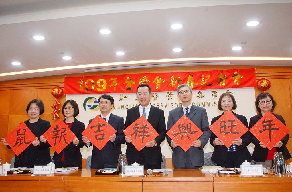 金管會14日下午舉行109年新春記者會,主委顧立雄(中)率領副主委張傳章(左3)、黃天牧(右3)與各局首長出席,拿起寫有「鼠報吉祥興旺年」的春聯向大眾拜年。中央社記者王騰毅攝 109年1月14日