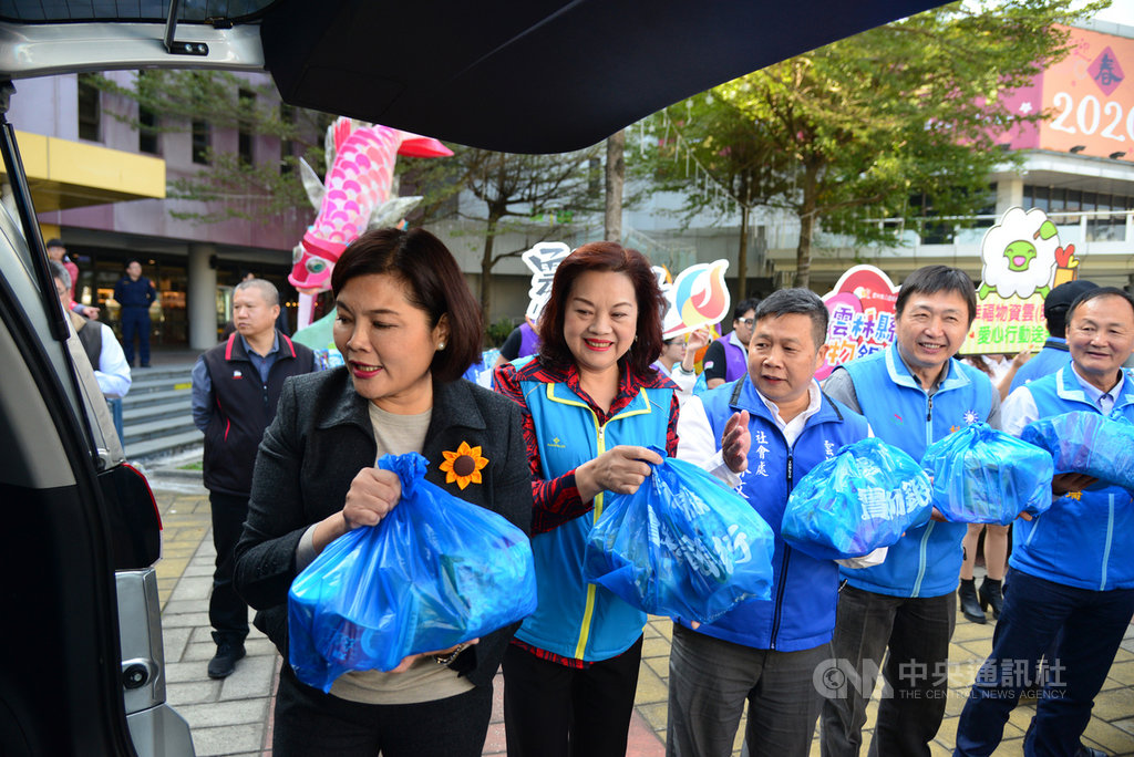 農曆春節將至,雲林縣長張麗善(前左)與縣議員、縣府主管及志工人員,15日將送給弱勢民眾的緊急及保暖物資裝袋,以接力的方式,送上轉運車。中央社記者蔡智明攝 109年1月15日