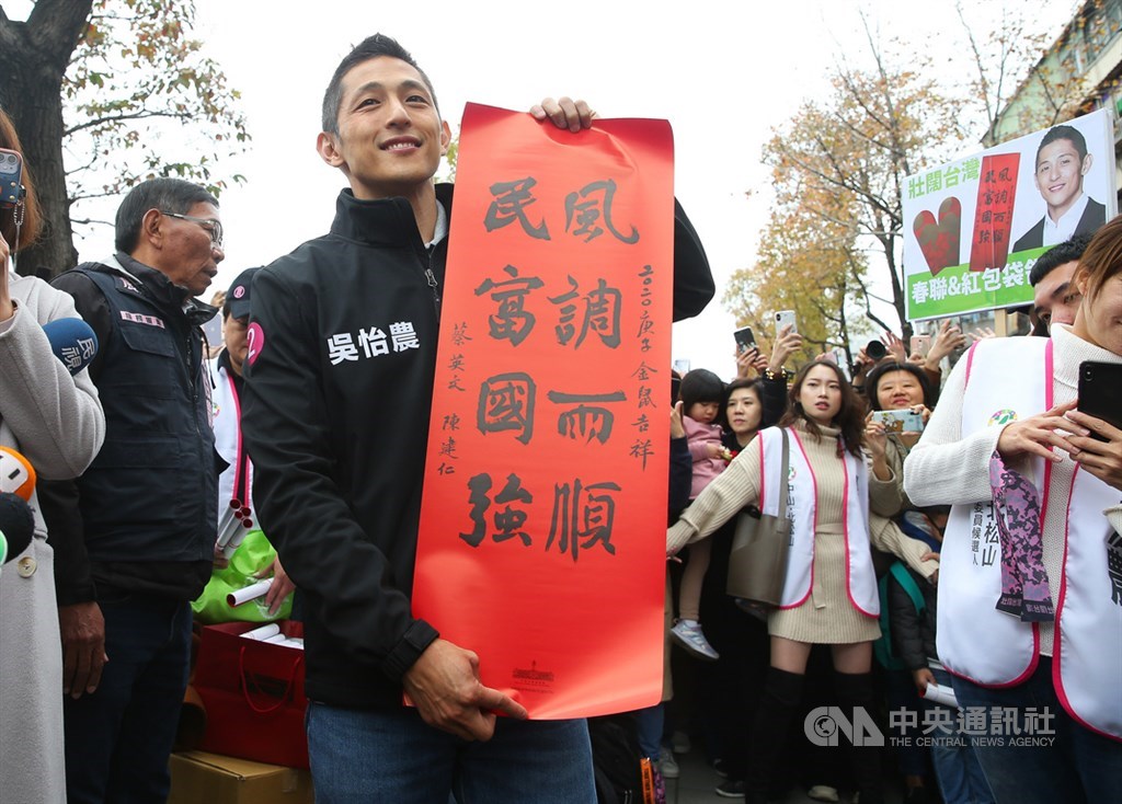 參選立委失利的民進黨候選人吳怡農(前)18日在台北市錦西街和民生西路70巷口發送春聯和紅包袋,向民眾拜早年。中央社記者謝佳璋攝 109年1月18日