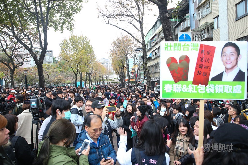參選立委失利的民進黨候選人吳怡農18日到台北市錦西街和民生西路70巷口進行謝票行程,並發送春聯與紅包袋,向民眾提早拜年,吸引大批民眾到場排隊領取。中央社記者謝佳璋攝 109年1月18日