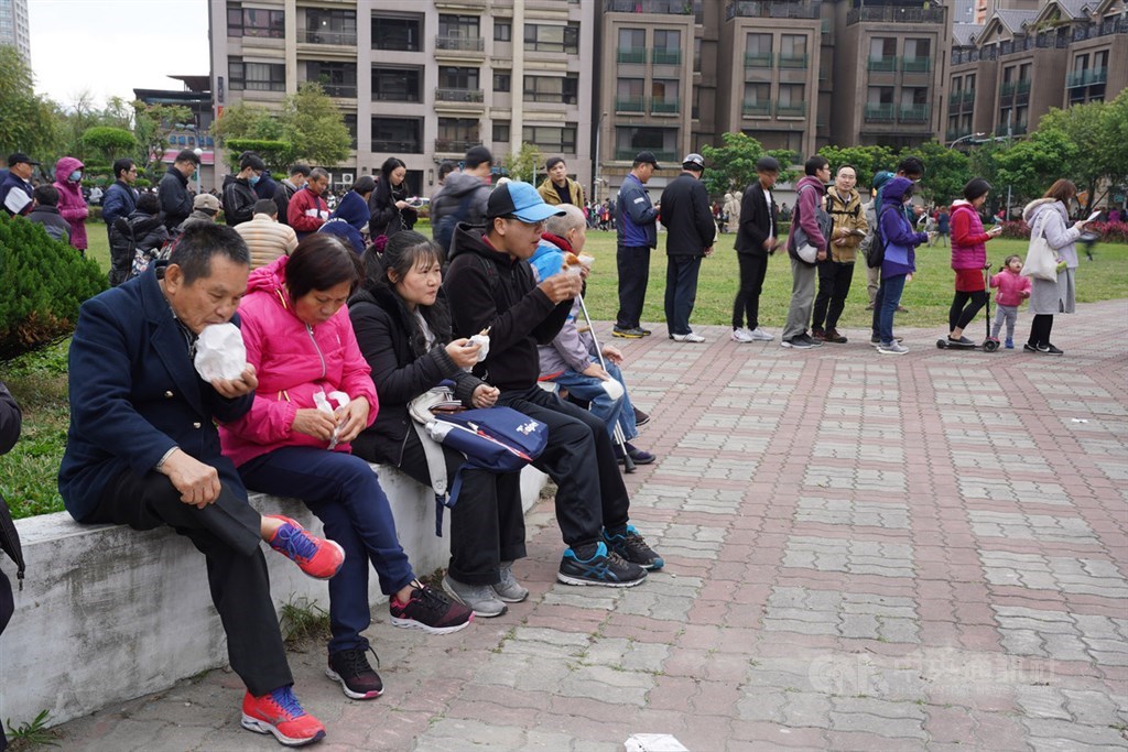 網紅「館長」陳之漢18日在新北市蘆洲區柳堤公園發2000份免費雞排,兌現選前承諾,先領到雞排的民眾開心在公園內享受美味,大批民眾則在後方繼續排隊。中央社記者徐肇昌攝 109年1月18日