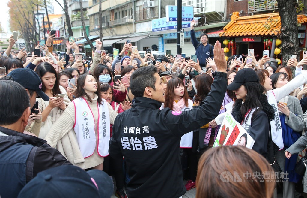參選立委失利的民進黨候選人吳怡農(前)18日在台北市錦西街和民生西路70巷口發送春聯和紅包袋,現場湧現人潮,高人氣的吳怡農未來動向受矚目。中央社記者謝佳璋攝 109年1月18日