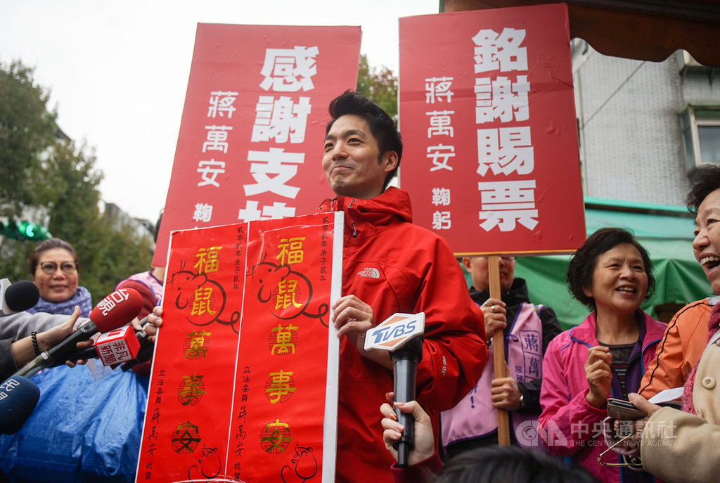 國民黨立委蔣萬安(前中)19日在台北市松山區草埔市場謝票,並準備春聯發放給民眾。中央社記者裴禛攝 109年1月19日