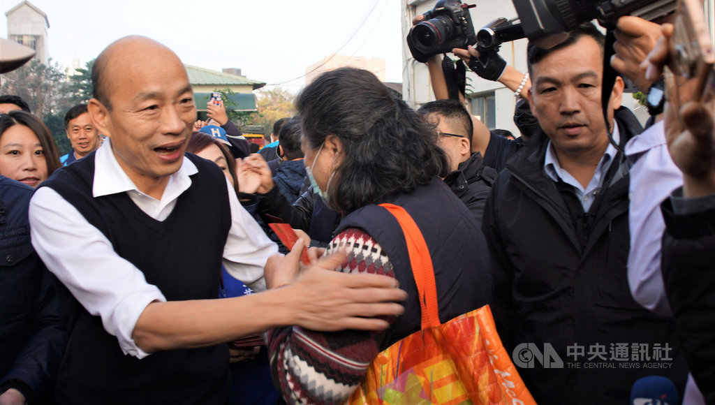 高雄市長韓國瑜(前左)19日巡訪高雄果菜批發市場並發放福袋,前來索取福袋民眾大排長龍,不少民眾也為他加油,場面熱烈。中央社記者程啟峰高雄攝 109年1月19日