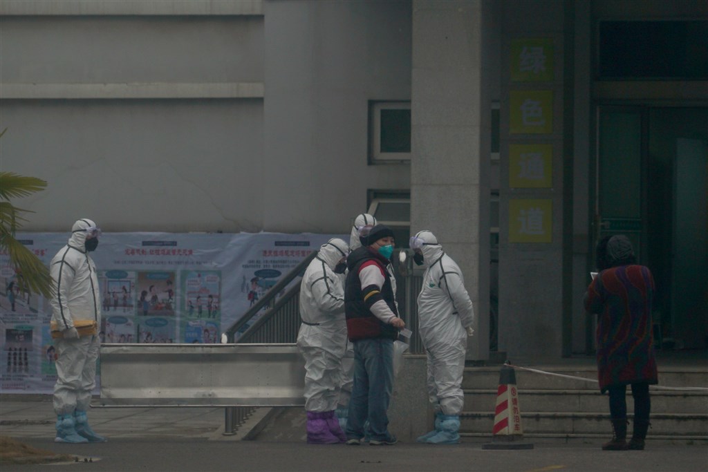 中國官方22日舉行記者會通報武漢肺炎疫情,截至21日晚上12時,中國共13省出現疫情,共確診440例。圖為武漢醫療救治中心外,醫護人員穿著防護隔離衣。(美聯社)