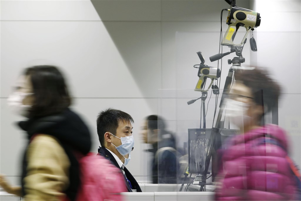 防範武漢肺炎,日本口罩需求增加,廠商接獲各地業者追加口罩的訂單,被迫趕工生產。圖為關西機場旅客及檢疫人員。(共同社提供)