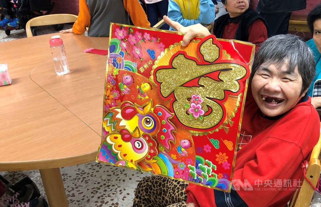 過年家家團圓,花蓮黎明教養院為院生安排春節布置活動,院生開心拿著春聯拍照。(黎明教養院提供)中央社記者張祈傳真 109年1月23日