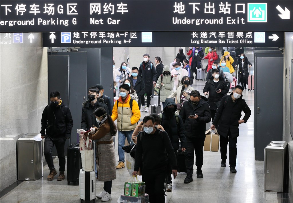 武漢肺炎疫情擴散,當地疫情防控指揮部宣布23日上午10時開始暫停公共運輸,無特殊原因不得離開武漢。圖為22日武漢漢口火車站地鐵口,不少人戴著口罩乘車回家。(中新社提供)