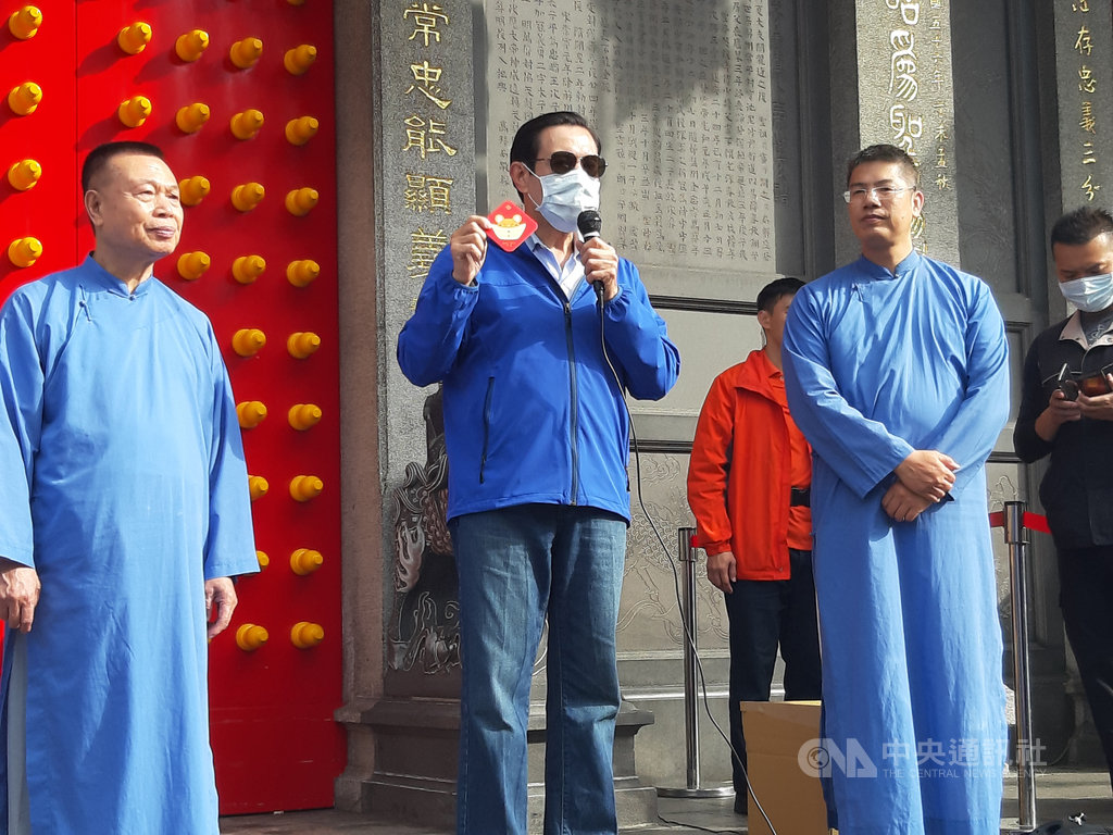 前總統馬英九(中)25日到行天宮祈福,並與行天宮人員一起發福卡及春聯,給祈福的民眾。中央社記者潘智義攝 109年1月25日