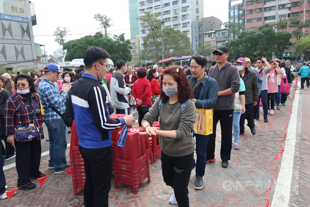 為防範武漢肺炎疫情擴大,副總統當選人賴清德25日在高雄市三鳳宮發放福袋,國安人員在現場設站為民眾的雙手噴消毒劑。中央社記者王淑芬攝 109年1月25日