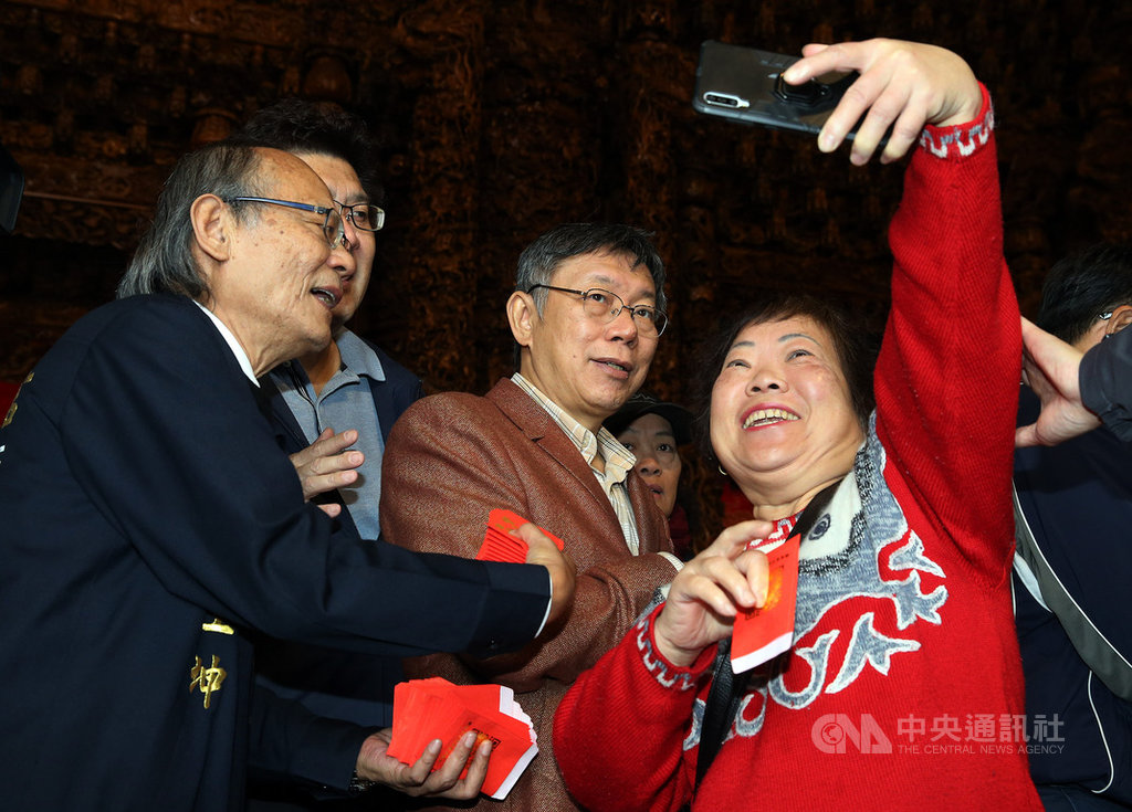 台北市長柯文哲(右2)大年初二到關渡宮參拜祈福,並向民眾發放小紅包,熱情民眾要求自拍合影。中央社記者郭日曉攝 109年1月26日