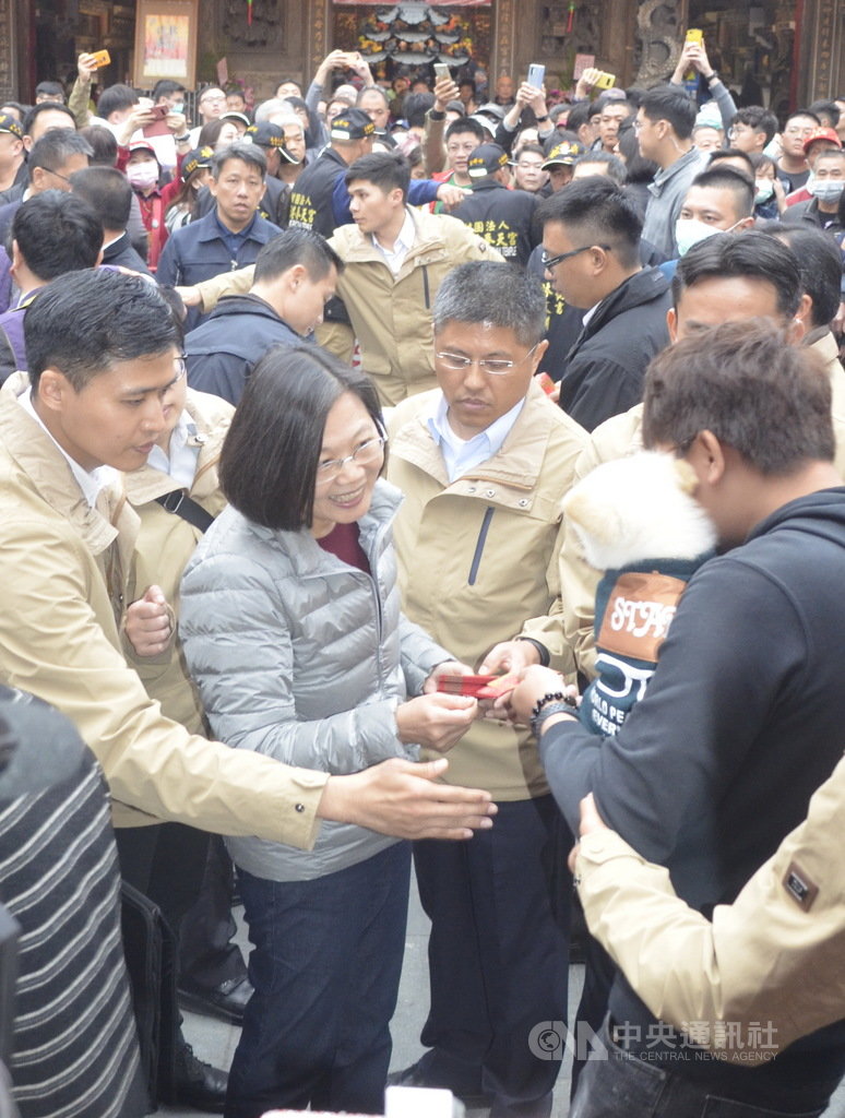 總統蔡英文27日在新港奉天宮發福袋,一位民眾抱著寵物狗狗來領福袋,總統流露欣喜的表情。中央社記者蔡智明攝 109年1月27日