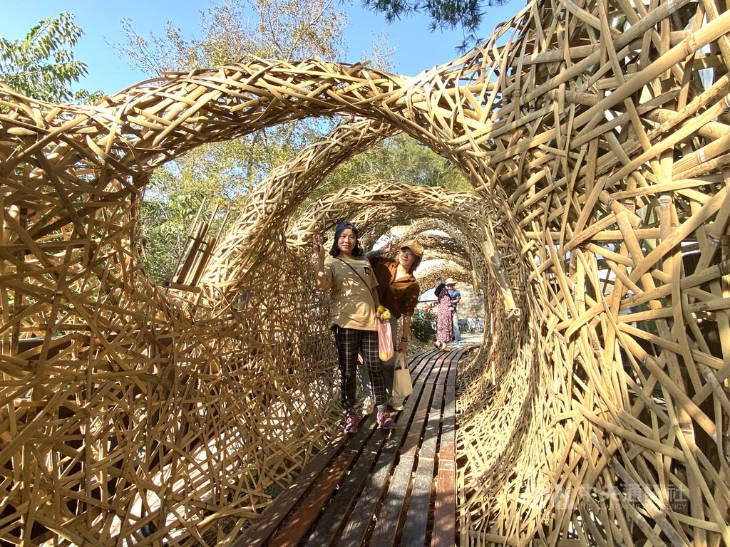印尼藝術團隊打造竹編地景藝術作品「流逝的時光」,輔以枕木、南方松打造成隧道般空間,寓意人因各種意識形態等而分化,未來終將一起面對全球暖化等環境問題。中央社記者郭宣彣攝 109年1月28日