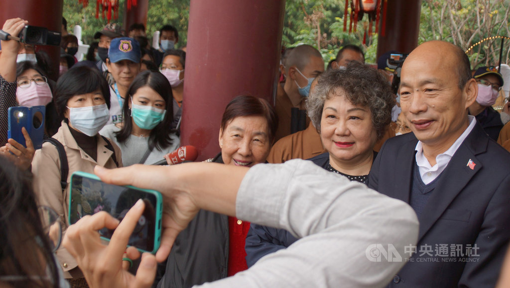 高雄市長韓國瑜(後右)28日至佛光山禮佛祈福,部分韓粉一路相隨簇擁為他加油,韓國瑜欲離去時應自稱來自美國紐約的韓粉要求脫下口罩與與他們合影。中央社記者程啟峰高雄攝 109年1月28日