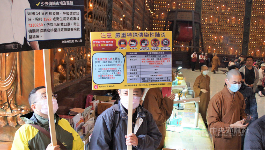 高雄市長韓國瑜28日至佛光山走春祈福,不忘宣導武漢肺炎防疫,圖為隨行人員一路舉牌向現場遊客及信徒宣導防疫。中央社記者程啟峰高雄攝 109年1月28日