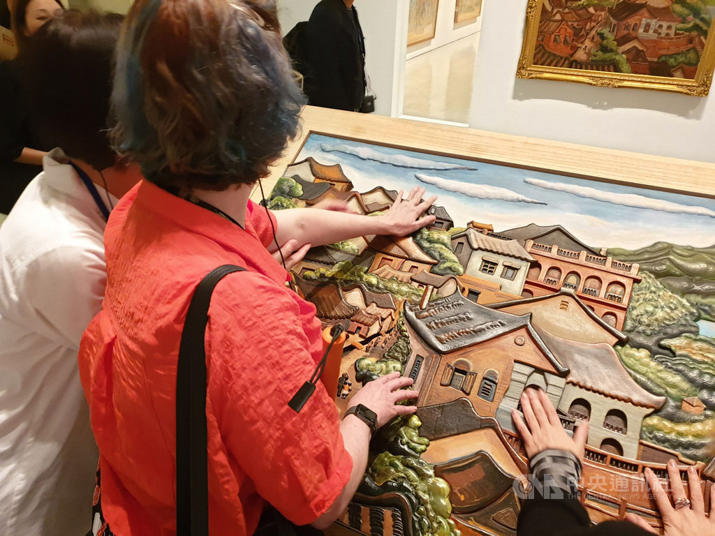 國立台灣美術館全人文化近用展將已故畫家陳澄波的「淡水風景」化為全台首見的畫作立體觸摸輔具,除了視障者,也讓所有觀眾透過觸摸開啟藝術感受力。圖為視障者使用畫作輔具。中央社記者陳偉婷攝 109年1月29日