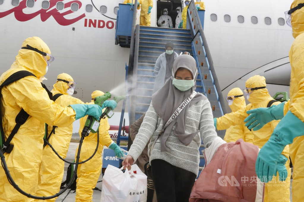 印尼政府的撤僑專機2日返抵巴淡島,自湖北省返國的國人下機後先噴灑消毒液,再搭軍機接駁至納土納縣的軍醫院隔離觀察。(印尼外交部提供)中央社記者石秀娟雅加達傳真 109年2月2日