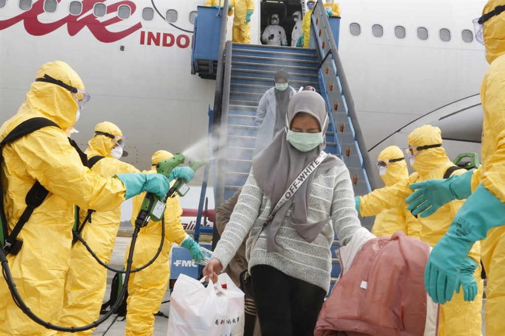 印尼政府的撤僑專機2日返抵巴淡島,自湖北省返國的國人下機後先噴灑消毒液,再搭軍機接駁至納土納縣的軍醫院隔離觀察。(印尼外交部提供)中央社記者石秀娟雅加達傳真 109年2月2日