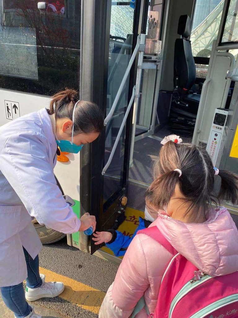 指揮中心3日宣布,有中港澳旅遊史的幼童,入境14天內禁送托。圖為2名首批滯留武漢返台的兒童在上車前消毒雙手。(台北家長會長協會提供)中央社 109年2月3日