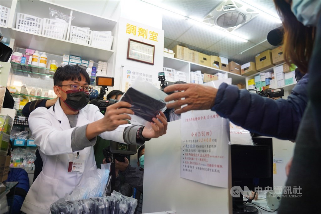 行政院10日表示,目前口罩產能每天已超過400萬片,增加超過70萬片產能傾向優先提供給醫院、基層診所醫護人員、慢性病患者與照顧者等3類別。圖為民眾持健保卡購買口罩。中央社記者徐肇昌攝 109年2月6日