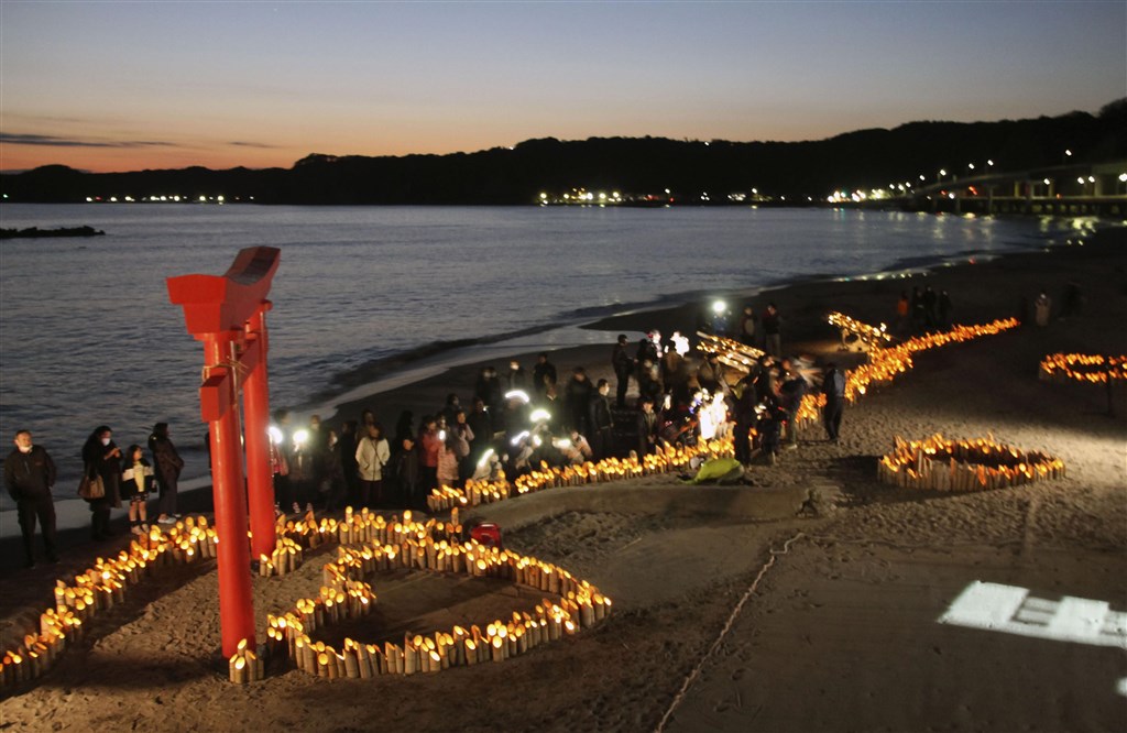 日本第一批從中國包機返鄉的日本人中,有176人被安置在千葉縣勝浦市的飯店觀察,有望從12日起依序返家。勝浦市居民11日晚間在飯店沙灘上投影訊息,為飯店內遭隔離的日人送暖。(共同社提供)