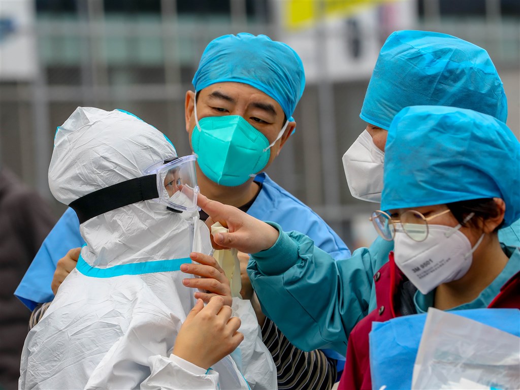 中國武漢肺炎新確診病例下降，但世界衛生組織表示，現在說疫情已達高峰或何時結束「還嫌太早了」。圖為武漢江岸塔子湖方艙醫院醫護人員進入醫院前做好防護措施。（中新社提供）