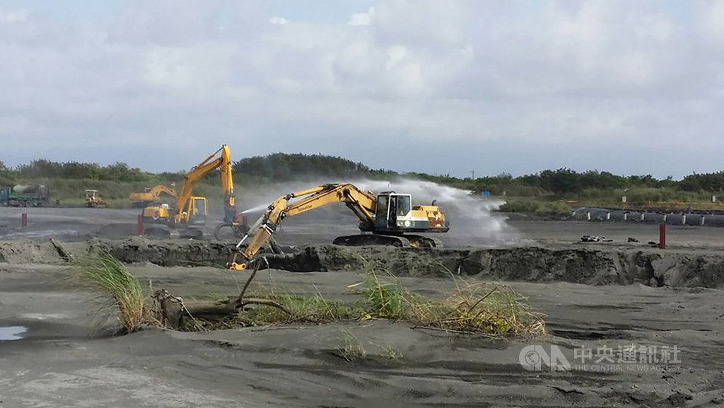 高雄市15日下午吹南風,強風造成高屏溪裸露的沙土揚塵嚴重,空氣品質惡化,經濟部水利署南區水資源局也啟動大型怪手壓實裸露沙土還噴灑水,以緩和揚塵。(高雄市環保局提供)中央社記者程啟峰傳真 109年2月15日