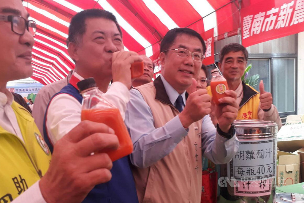 台南市長黃偉哲(右2)16日出席將軍胡蘿蔔農業產業文化活動,試喝現場攤位展售的胡蘿蔔汁。(台南市農業局提供)中央社記者楊思瑞台南傳真 109年2月16日