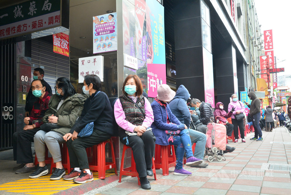 寒流來襲,口罩需求仍持續發燒,位於新北市板橋區的一家藥局17日中午排隊人潮綿延50公尺,民眾在寒風中等待購買口罩。中央社記者黃旭昇新北攝 109年2月17日