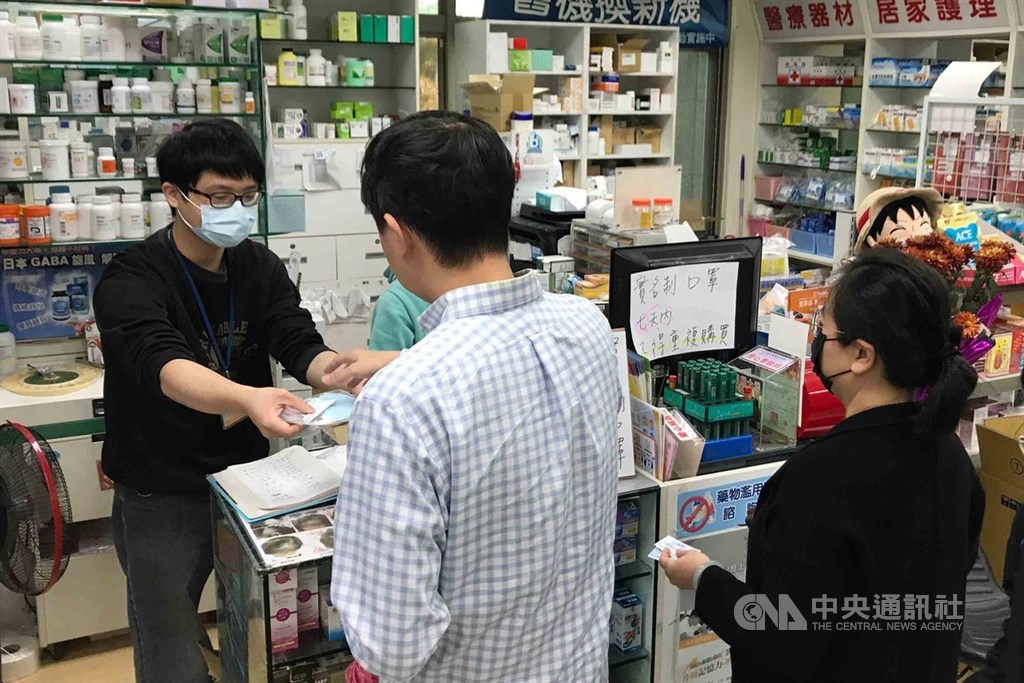 中央流行疫情指揮中心17日晚宣布,因口罩產能穩定提升且即將開學,20日起每位12歲以下兒童7天可購買4片口罩,每家健保合作藥局每日配送的兒童口罩片數加倍為200片,共50人份。圖為民眾到藥局買口罩。(中央社檔案照片)