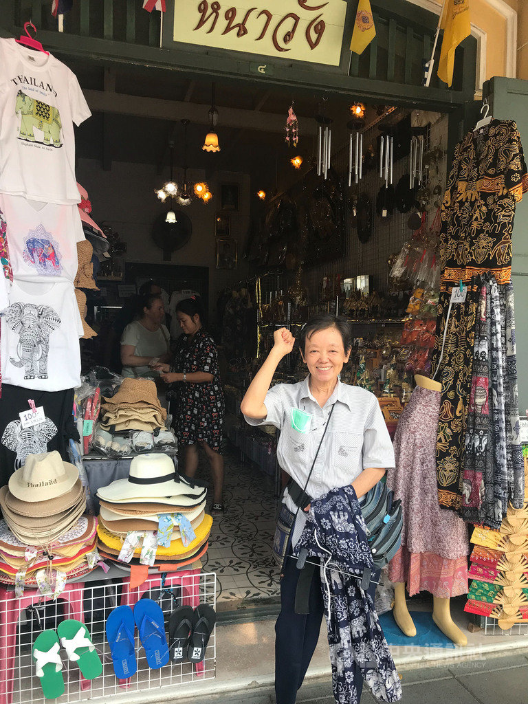 受到中國遊客銳減影響,在大皇宮外販售紀念品的泰國商販生意大為減少,店家舉手對著鏡頭喊「加油」,希望武漢肺炎疫情趕快好轉。中央社記者呂欣憓曼谷攝 109年2月19日