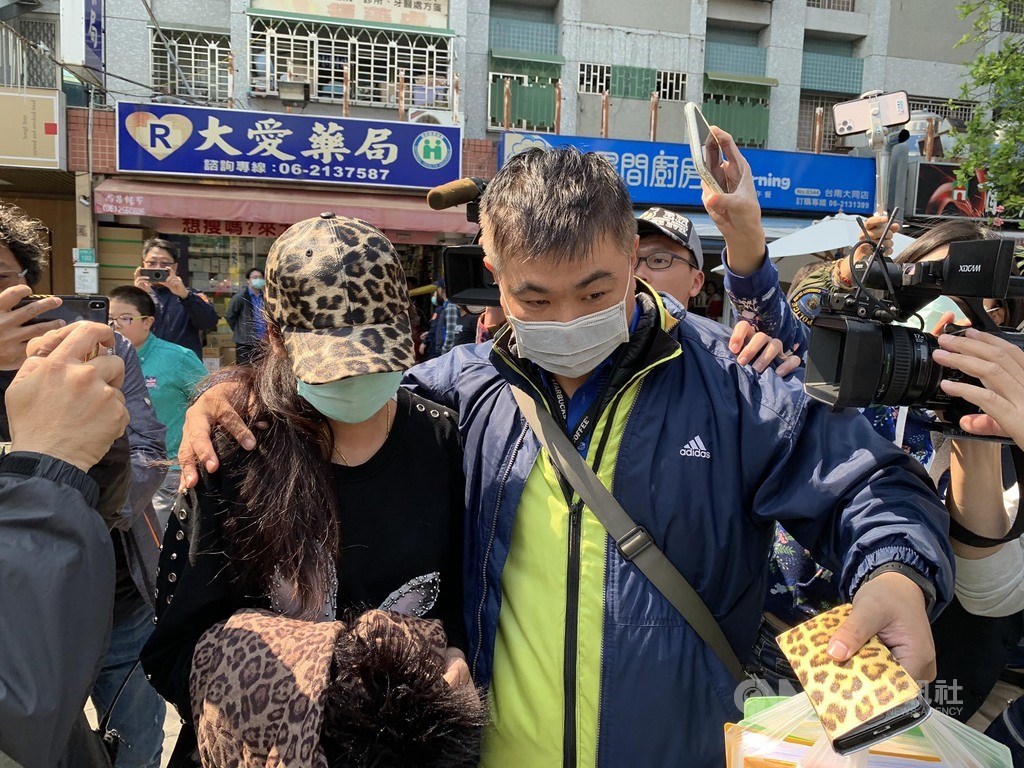 台南市東區大愛藥局遭爆料囤積百萬片口罩,台南檢警調19日封鎖現場搜索,卻查無實證;陳姓業者(左)仍被警方護送前往台南地檢署應訊,釐清案情。中央社記者張榮祥台南攝 109年2月19日