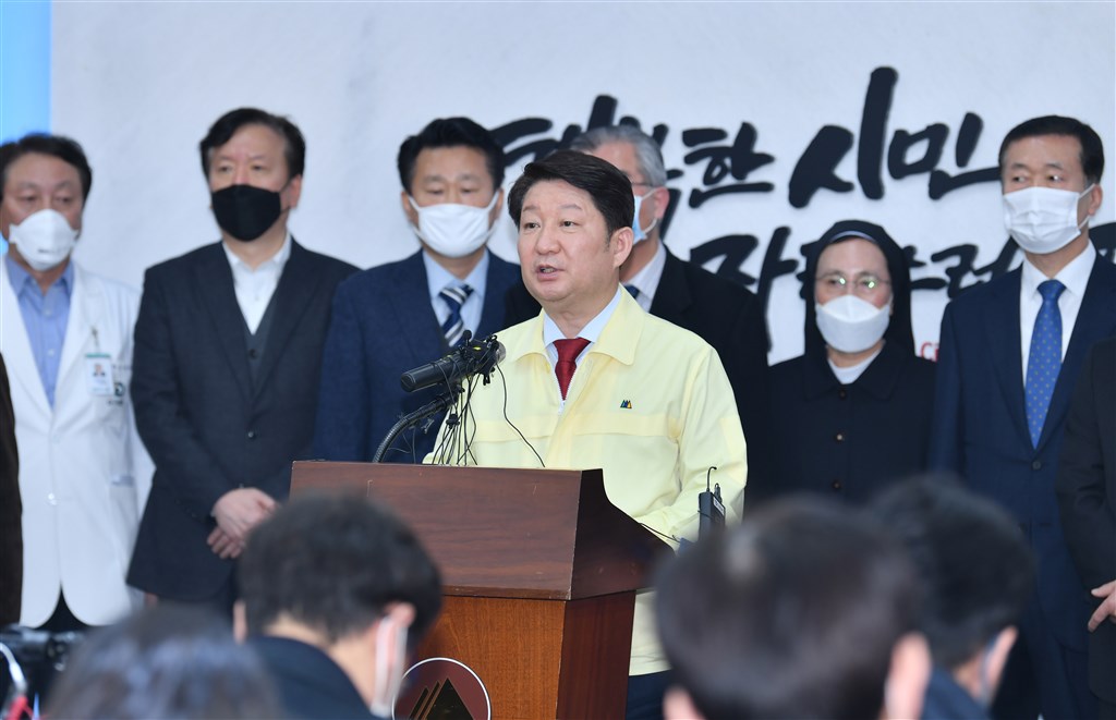 韓國政府20日表示,新型冠狀病毒疾病已突破防疫網,呈現社區感染及擴散蔓延的跡象。圖為大邱市長權泳臻(黃衣)發表武漢肺炎疫情爆發聲明。(韓聯社提供)