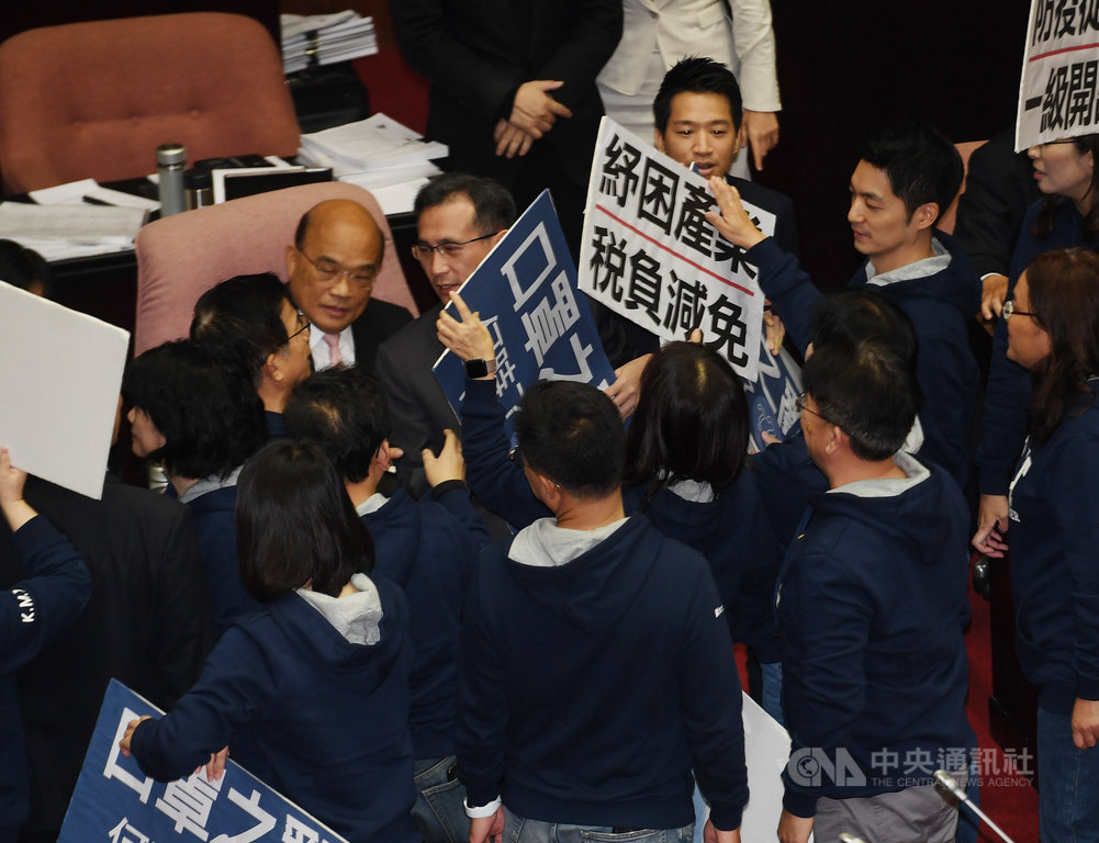 立法院21日開議,國民黨立委在議場內高舉「口罩之亂何時了」、「防疫從嚴 一級開設」等標語看板,並到行政院長蘇貞昌(後左)座位前呼口號說明訴求與立場。中央社記者施宗暉攝 109年2月21日