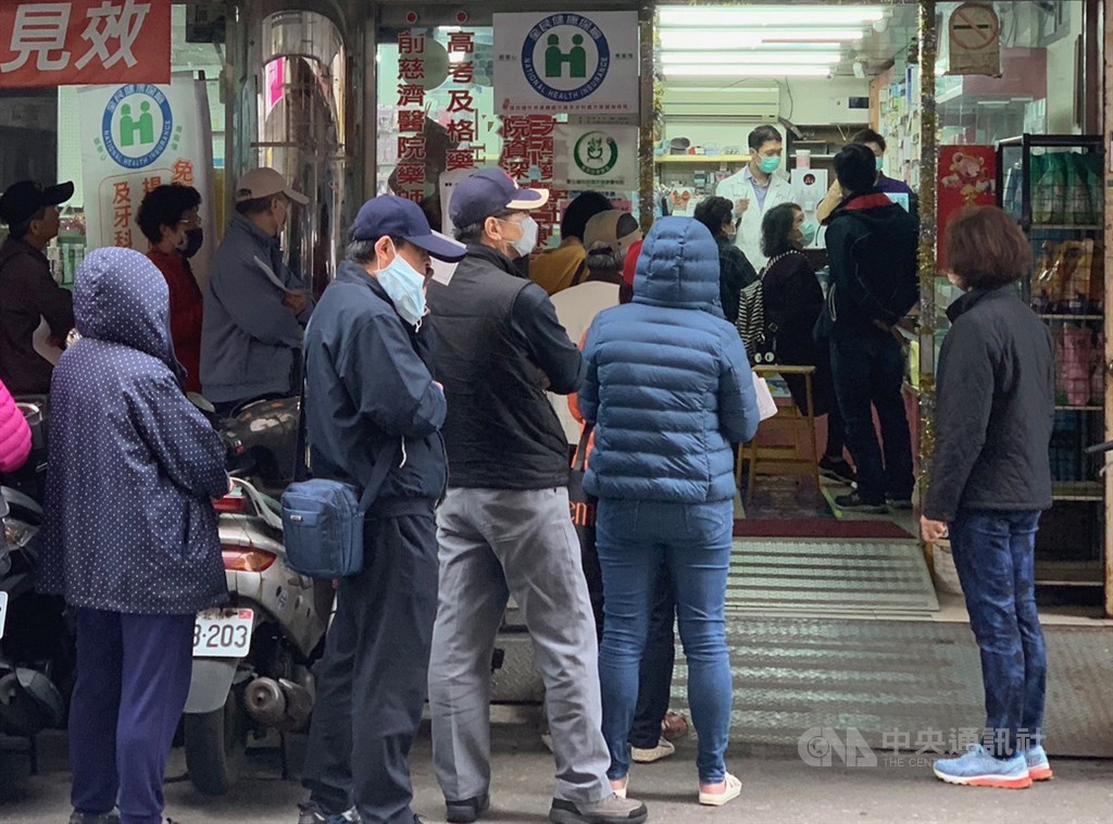 武漢肺炎疫情嚴峻,台灣自6日起實施口罩販售實名制,20日仍可見許多民眾在藥局門口排隊等待購買。中央社記者張新偉攝 109年2月20日