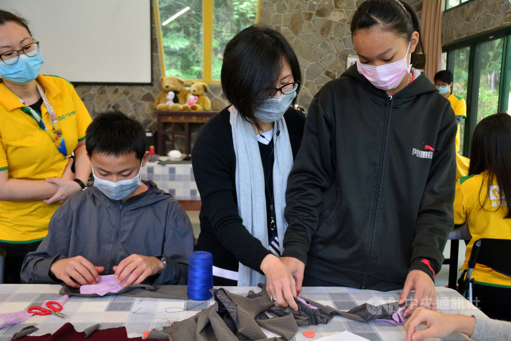 新北市基督教芥菜種會愛心育幼院安排院生學習縫製布口罩,由推動「零廢棄觀念」志工陳嫦玫(左3)現場指導。中央社記者黃旭昇新北攝 109年2月22日