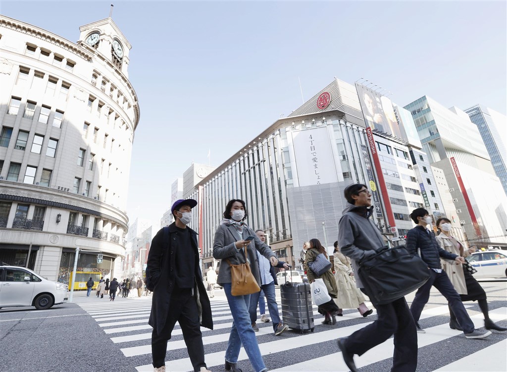 中央流行疫情指揮中心22日將日本及韓國升級至旅遊疫情第二級,旅遊業者說,先前日韓疫情升溫時,旅遊團就約已退了一半,預期未來還可能退更多。圖為東京銀座街頭民眾戴口罩。(共同社提供)