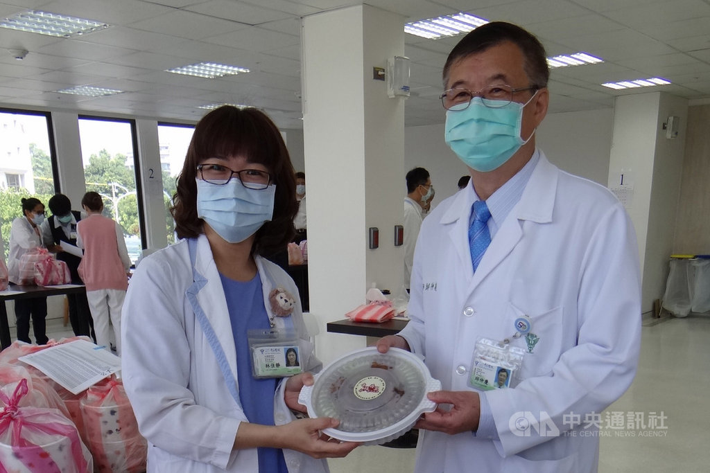 奇美醫學中心獲東成醬油公司捐贈5000份豬腳麵線與茶葉蛋,院長邱仲慶(右)24日將首批暖食轉發給第一線的醫護人員。中央社記者楊思瑞攝 109年2月24日