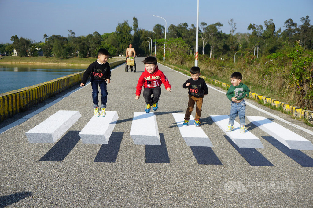 金門縣漂浮斑馬線位於金湖鎮中正公園內,太湖淨水廠旁的壩堤上,創作者是廖駿杰和陳詩薏,不少民眾慕名而來,爭相站在最佳拍攝點搶拍打卡,小朋友也站在斑馬線上開心跳躍。中央社記者黃慧敏攝 109年2月24日
