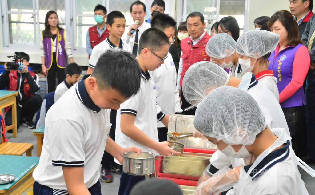 新北市政府24日在板橋區大觀國小舉行校園防疫演練,中午用餐時,打飯菜學生穿戴好服裝,領餐學生則落實用餐禮儀,避免飛沫噴濺造成傳染。中央社記者黃旭昇新北攝 109年2月24日
