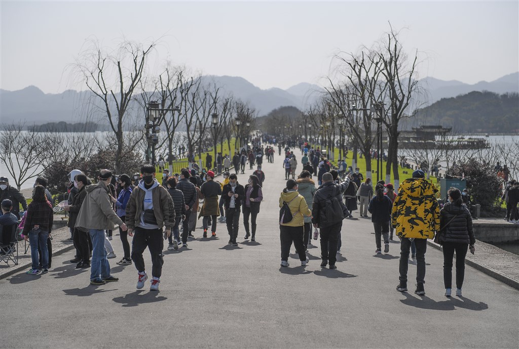 武漢肺炎在中國的疫情暫時有趨緩跡象,近日多地有民眾群聚購物出遊,讓官媒疾呼不可。圖為22日浙江杭州白堤湧進不少遊客。(中新社提供)