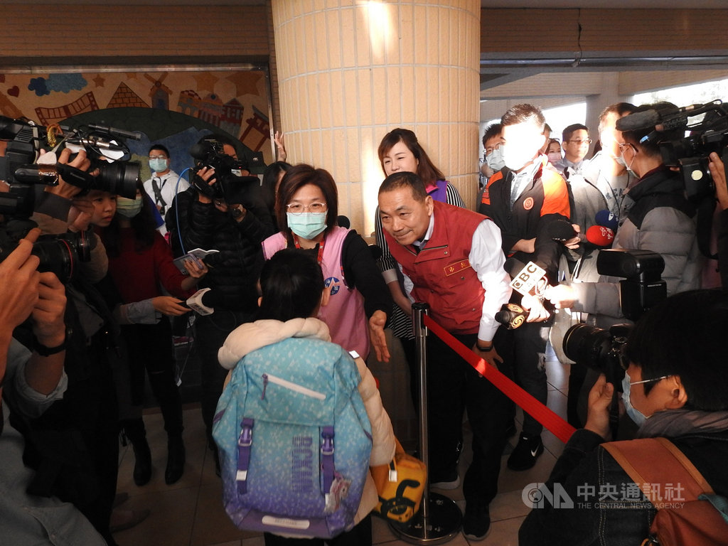 新北市長侯友宜(紅背心者)25日視察板橋海山國小武漢肺炎防疫情形, 一一慰勉教職員辛勞,並詢問學童是否有量體溫。中央社記者王鴻國攝 109年2月25日
