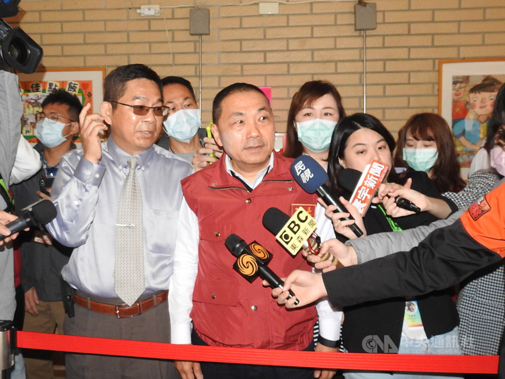 武漢肺炎疫情延燒,新北市長侯友宜(前中)25日前往板橋海山國小視察,聽取校長林瑞昌(前左)說明校園防疫措施,瞭解學童入校量體溫情形。中央社記者王鴻國攝 109年2月25日